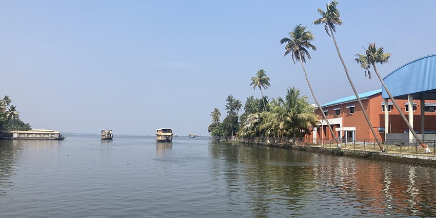 A scenic view of backwaters in Kerala with clear skies and lush greenery all around