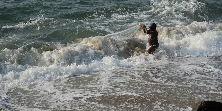 A fisherman on the beach in Fort Kochi, one of the ideal places to visit in Kerala for couples