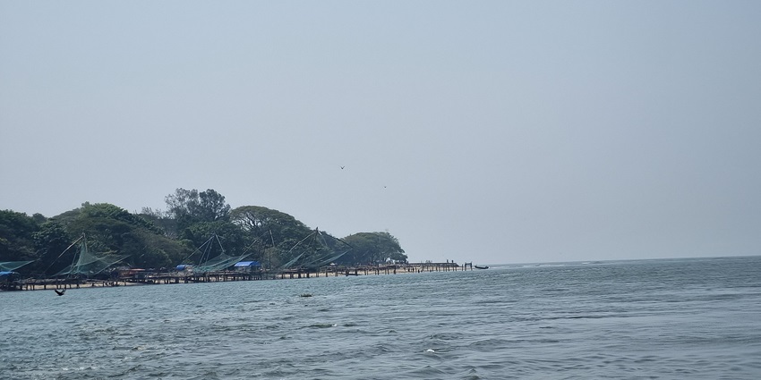 Ferry boat sailing across calm waters near Fort Kochi with scenic views of the coastline.