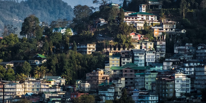 View of Gangtok from Tibet Road - lush greenery mountains and beautiful white buildings
