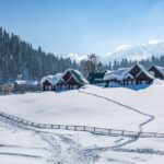 The backdrop of snow-capped mountains and lush green peaks in the beautiful Gulmarg