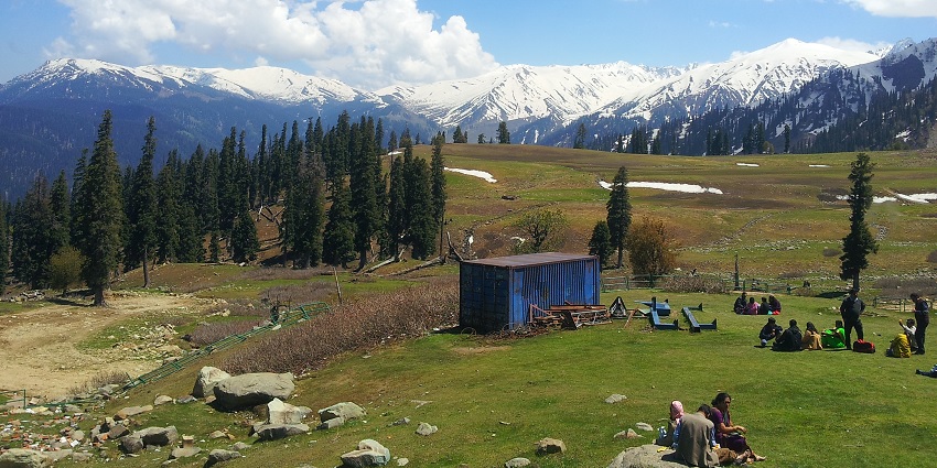Gulmarg’s view with green valleys in the front and snow covered mountains in the backdrop.