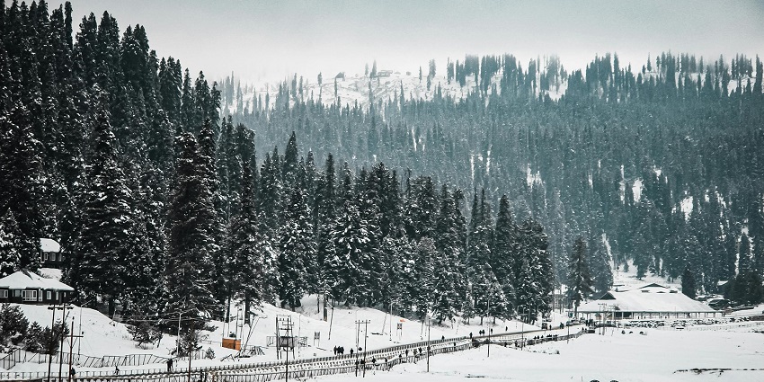 A landscape capture of Gulmarg’s gondola route with thick snow-covered peaks all around