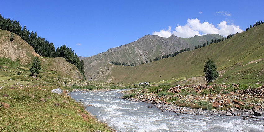 An image of winding river through Gurez Valley’s lush green meadows and mountains