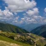 A breathtaking view of Gurez Valley with lush green hills covered under dense clouds.