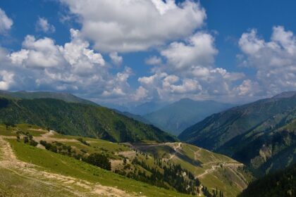 A breathtaking view of Gurez Valley with lush green hills covered under dense clouds.