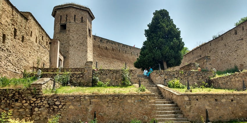 A view of Hari Parbat Fort with tourists sitting under a tree on the fort’s premises