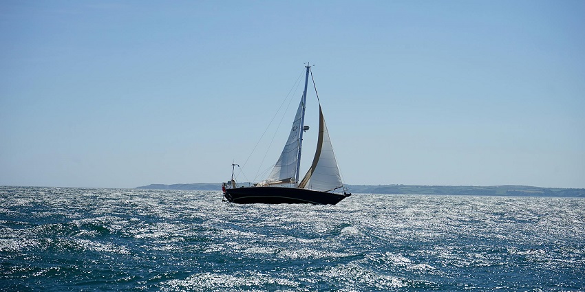 A sailboat on an ocean with low waves. A boat can be used to reach this Island in Andaman.