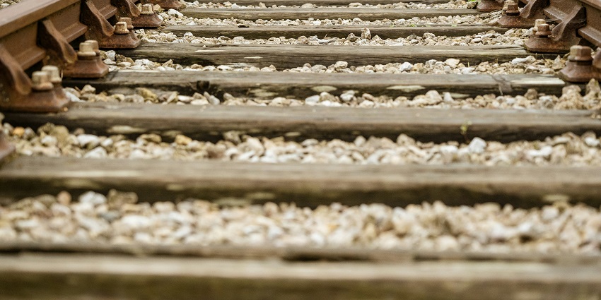 A close-up view of a railway track with a lot of rocks on it during the daytime.