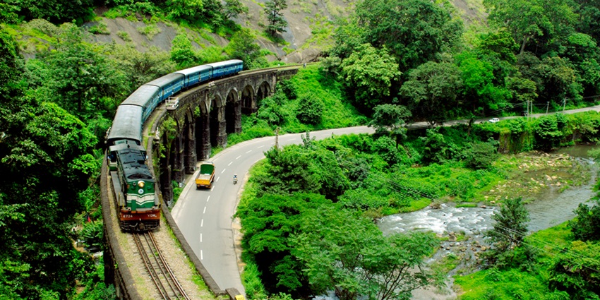 A train moving through a beautiful hilly area