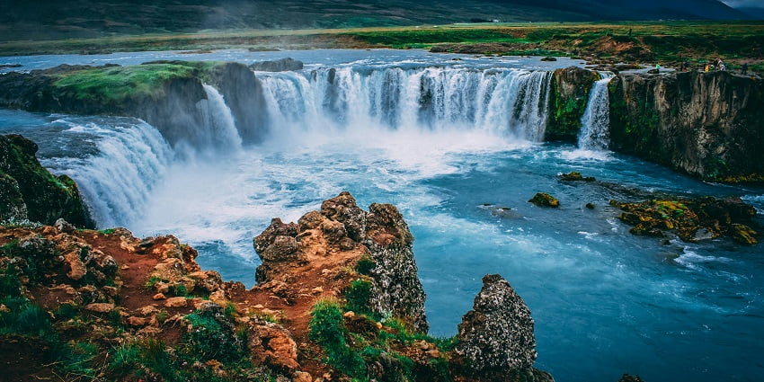 A captivating view of the scenic beauty of cascading waterfalls in Iceland with cloudy sky