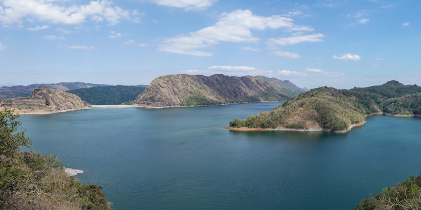An aerial picture of a reservoir in Idukki, surrounded by two dams and a number of small hills