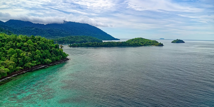 An Island surrounded by clear blue water and lush greenery - private islands in Kerala