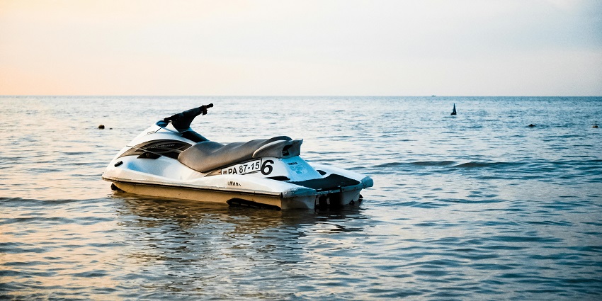 A view of a watercraft on a body of water during the daytime with sunlight falling on it.