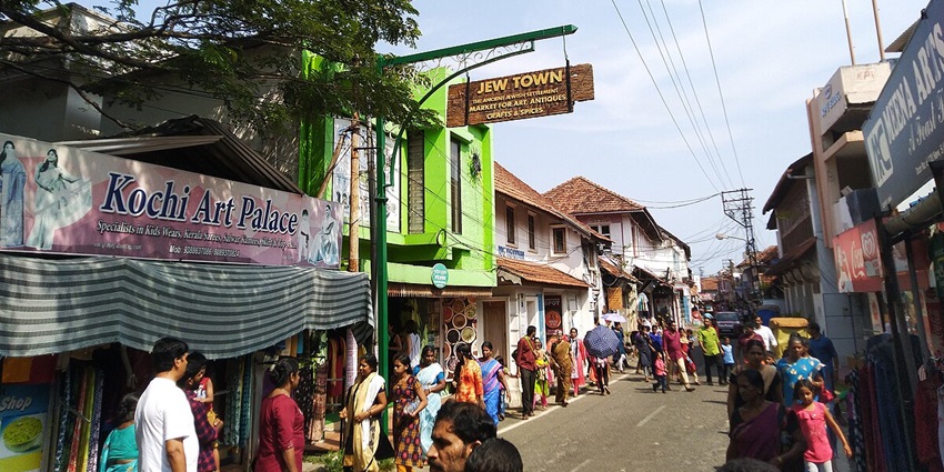 A daytime view of people exploring the bustling markets of Jew Town in Kochi, Kerala