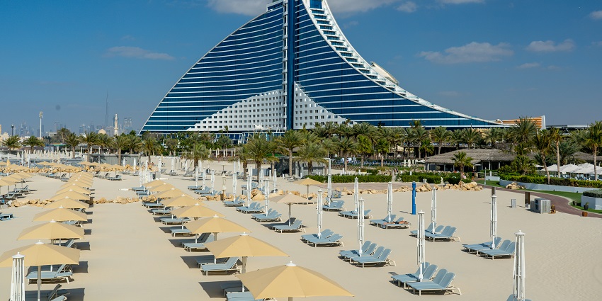 A stunning view of a hotel in front of the Jumeirah Public Beach during the daytime.