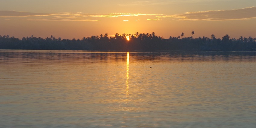 A majestic view of a sunrise from a river bank, with golden hues spread all around