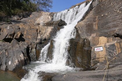 A breathtaking view of Kanthanpara Waterfalls in Kerala surrounded by lush green trees.