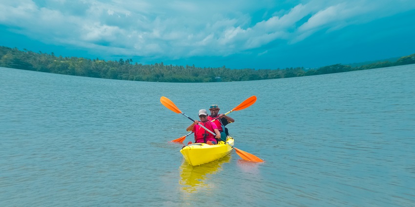 It is a photo of couple kayaking in Kerala backwaters - best water sports in Kerala