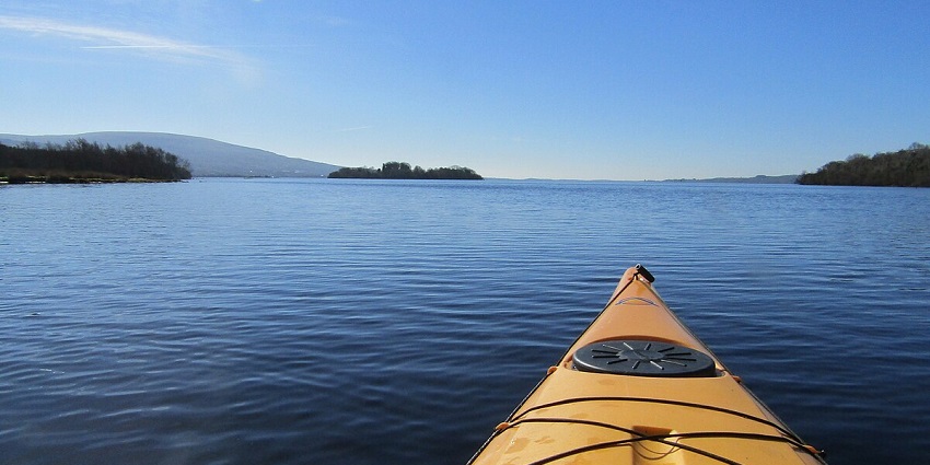 A breathtaking view of a kayak on an ocean with turquoise water and clear blue sky.