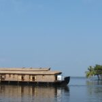 Houseboat on the picturesque backwater of Kerala with a backdrop of Coconut trees