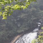 Majestic Thindillam waterfalls cascading down rocks surrounded by lush greenery in Kerala.