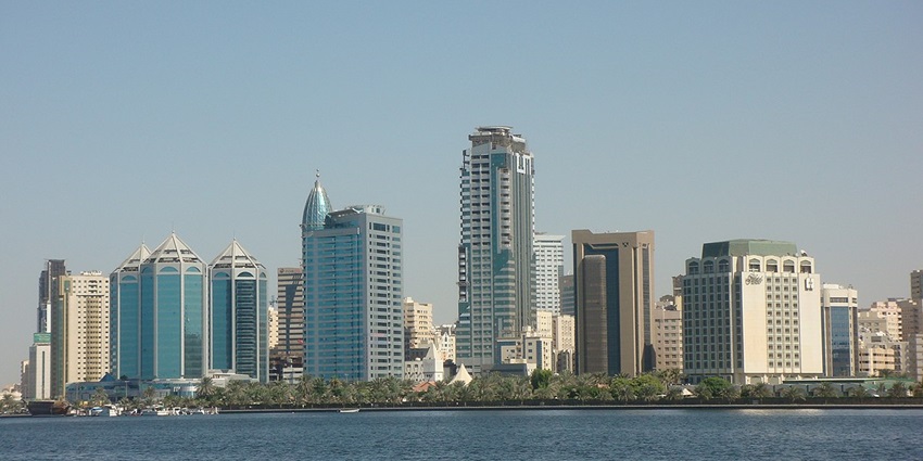 Serene waters surrounded by modern skyline and lush parks - best things to do in Sharjah