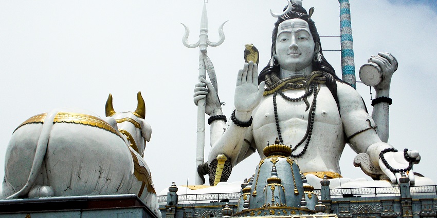 A mesmerising view of a statue of lord Shiva in front of Lord Nandi during the day.