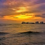 A breathtaking view of a water body in Kochi during sunset near white buildings.