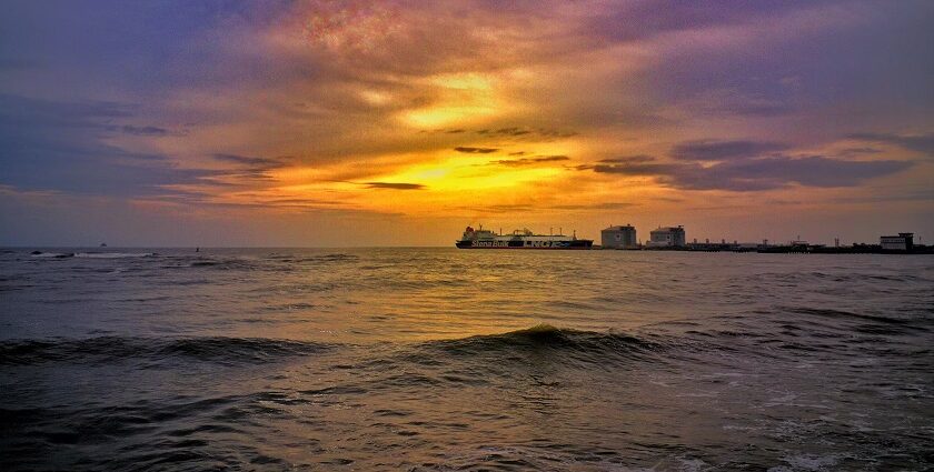 A breathtaking view of a water body in Kochi during sunset near white buildings.