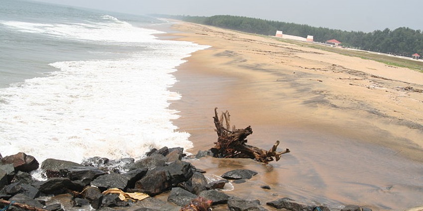 A sea shore with sand on the right side