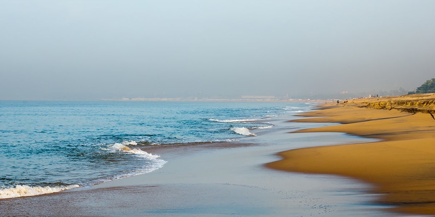 View of Kollam beach, golden sand & clear blue water - explore private islands in Kerala