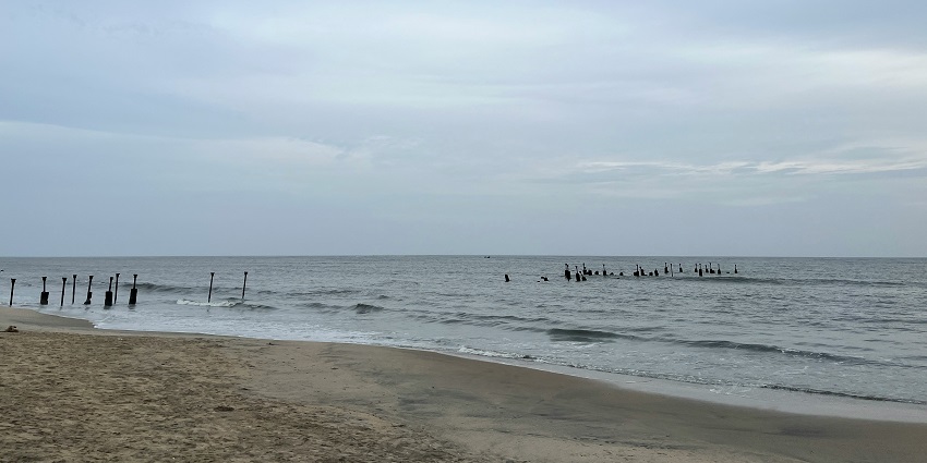 Stunning view of Kozhikode Beach with azure waters and crystal clear sky in the backdrop.