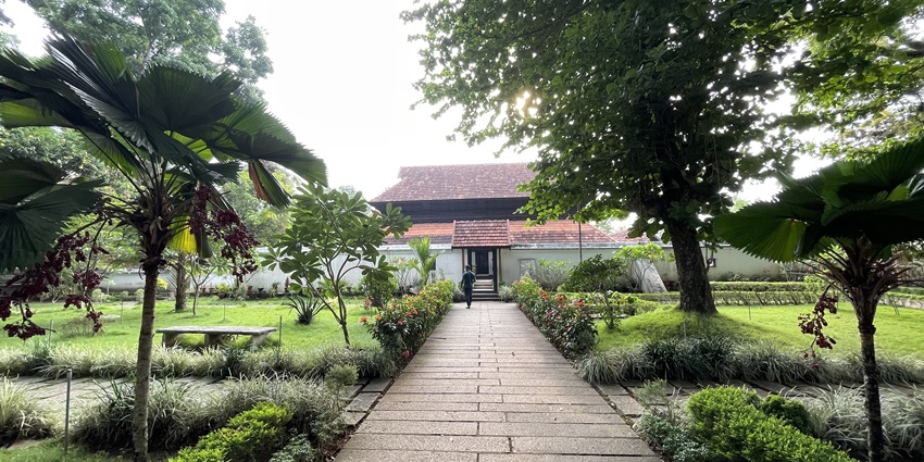 Majestic front view of Krishnapuram Palace with lush green lawn in foreground