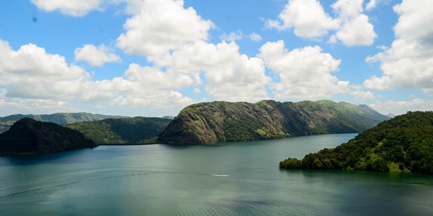 Top view of the Kulamavu dam reservoir looking over the hills and dense forests beyond