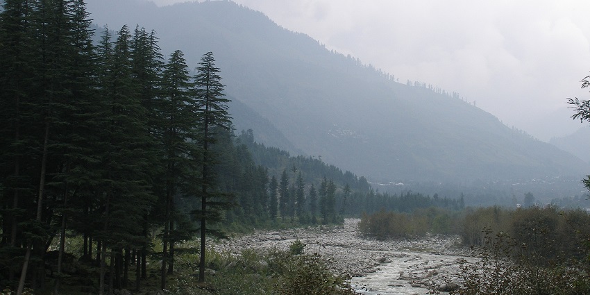 Picturesque view of the Kullu valley, a river meandering through the forested hills