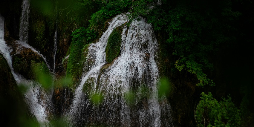 An image of a surreal waterfall with lush greenery around, similar to Kurisadi waterfall