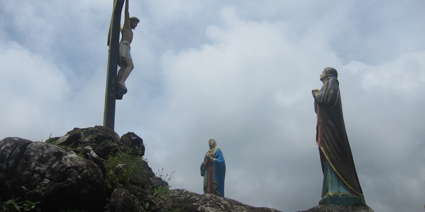 A glimpse of the top of the Kurisumala Hill featuring a sculpture of God and a cross.