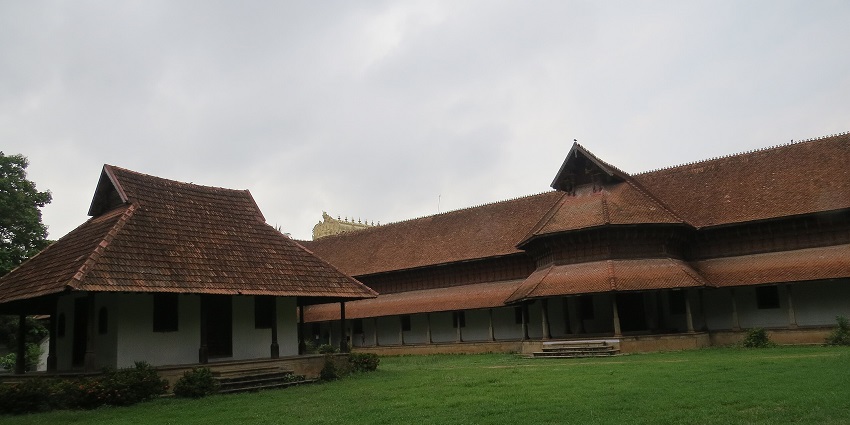Image of Kuthiramalika Palace, surrounded by greenery with clear blue sky in background