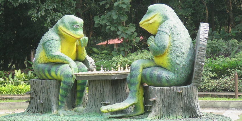 The statues of two frogs playing chess in the beautiful Nilampur Teak Garden park