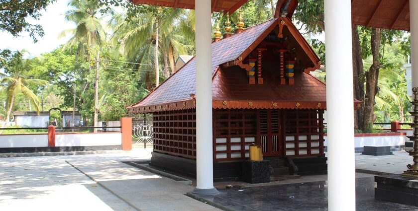 Stunning view of a red-roofed wooden structure in Malappuram surrounded by lush greenery.