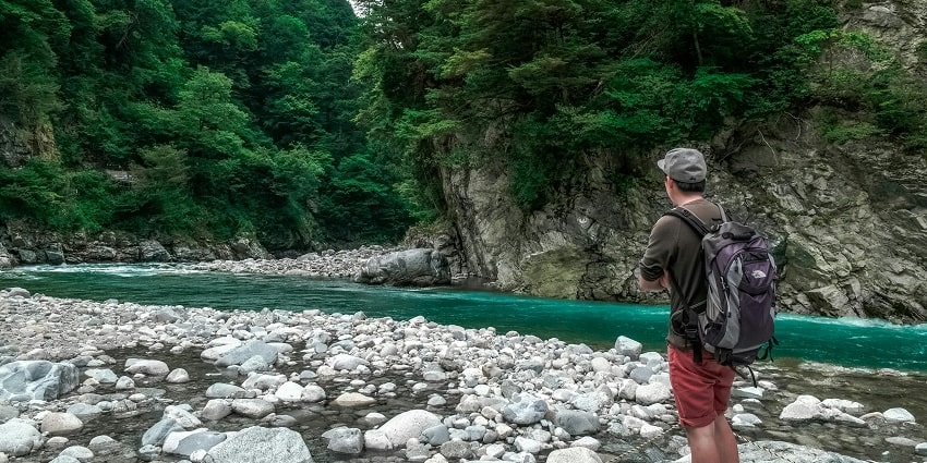 Man Staring at Flow of Water Outdoors on trek - pack your essentials for your journey