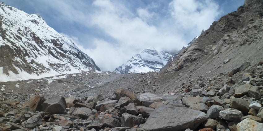 High-altitude glacial lake nestled among rugged Himalayan peaks under a clear blue sky