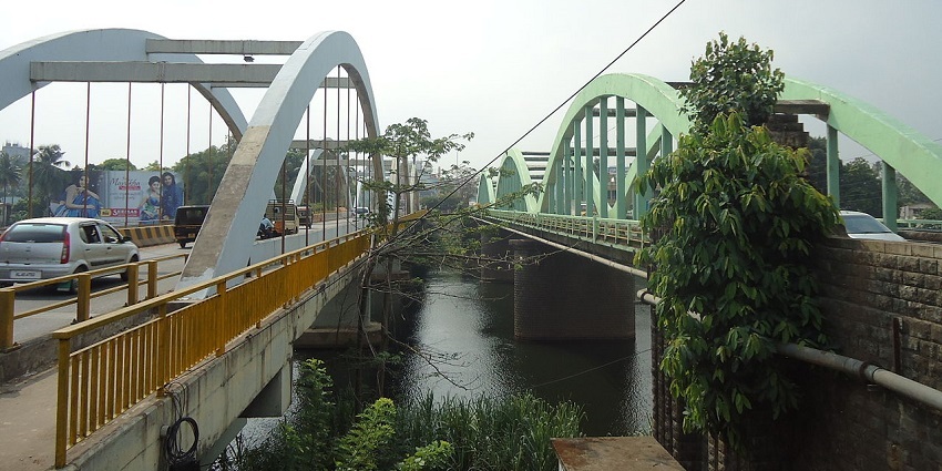 Marthanda Varma Bridge spanning across a river, scenic views of the water and greenery.