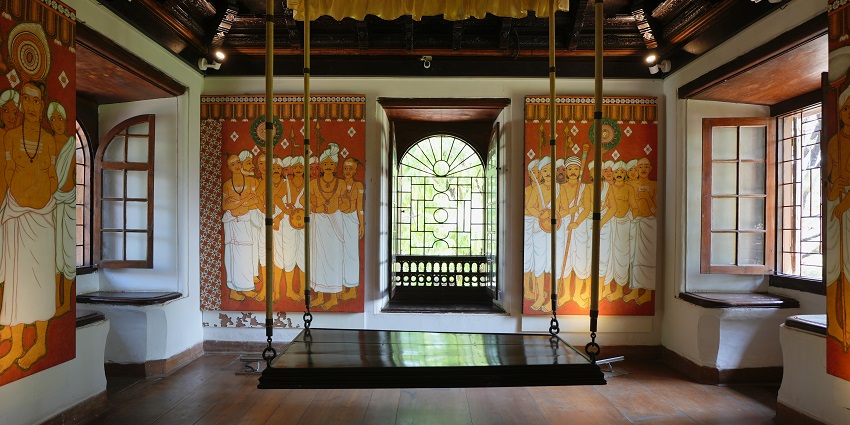 Vibrant tapestries hanging on the walls of the throne room of Mattancherry palace