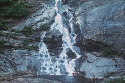 Cascading over rocks surrounded by dense forest and greenery - explore Attapadi waterfalls