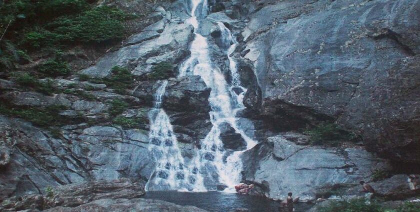 Cascading over rocks surrounded by dense forest and greenery - explore Attapadi waterfalls