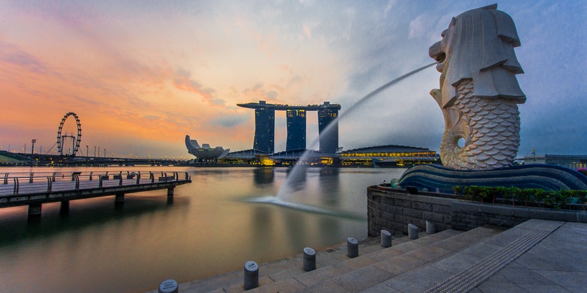 Rear view of Merlion statue spouting water, with Marina Bay Sands in the background