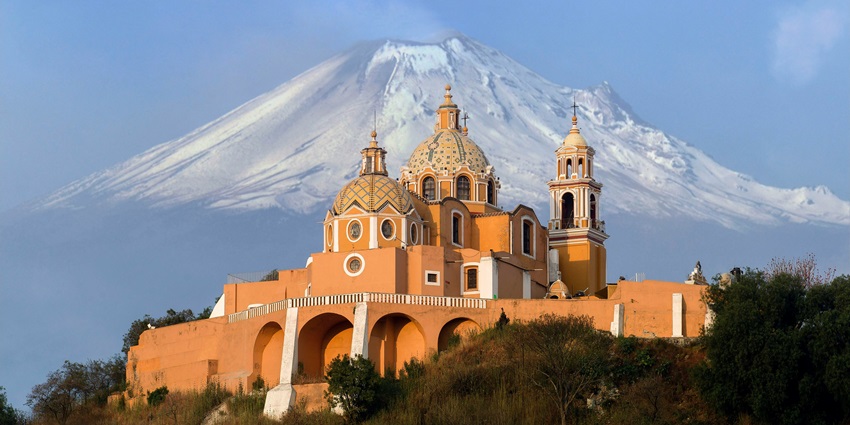 A captivating view of a church in Mexico with a snow-clad mountain in the background