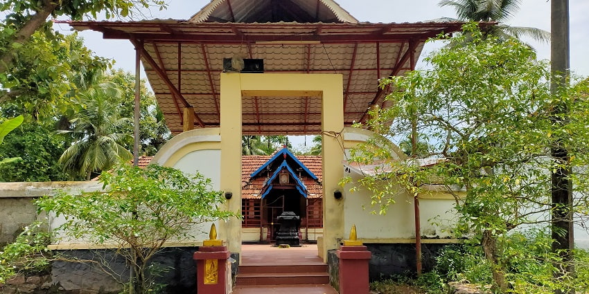 A stunning view of Mullakkal Bhagavathy Temple with red steps and lush greenery around it.